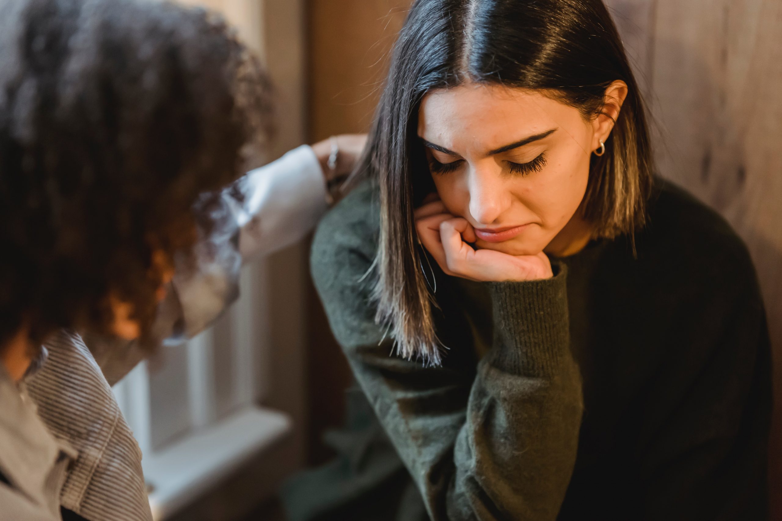 a woman counsels another woman experiencing negative emotions