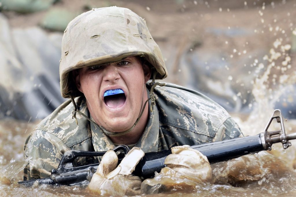 soldier with gun plunges through water with war cry