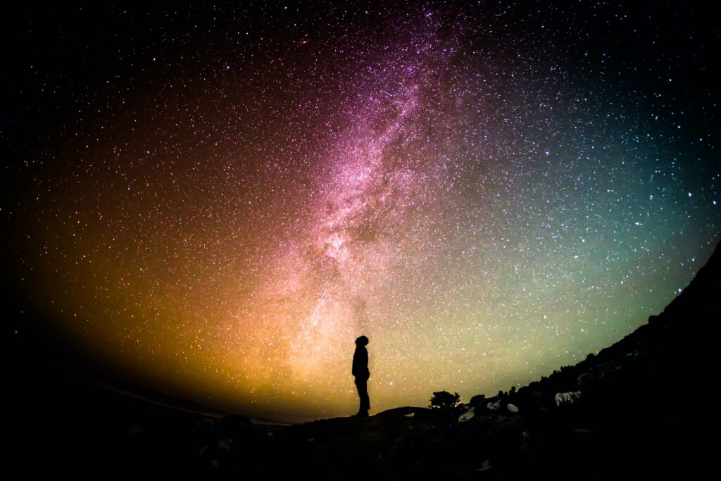 man stands gazing at the stars