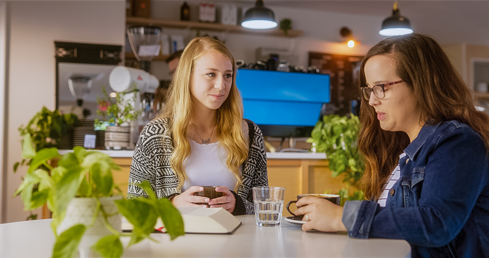 two women talk in a coffee shop