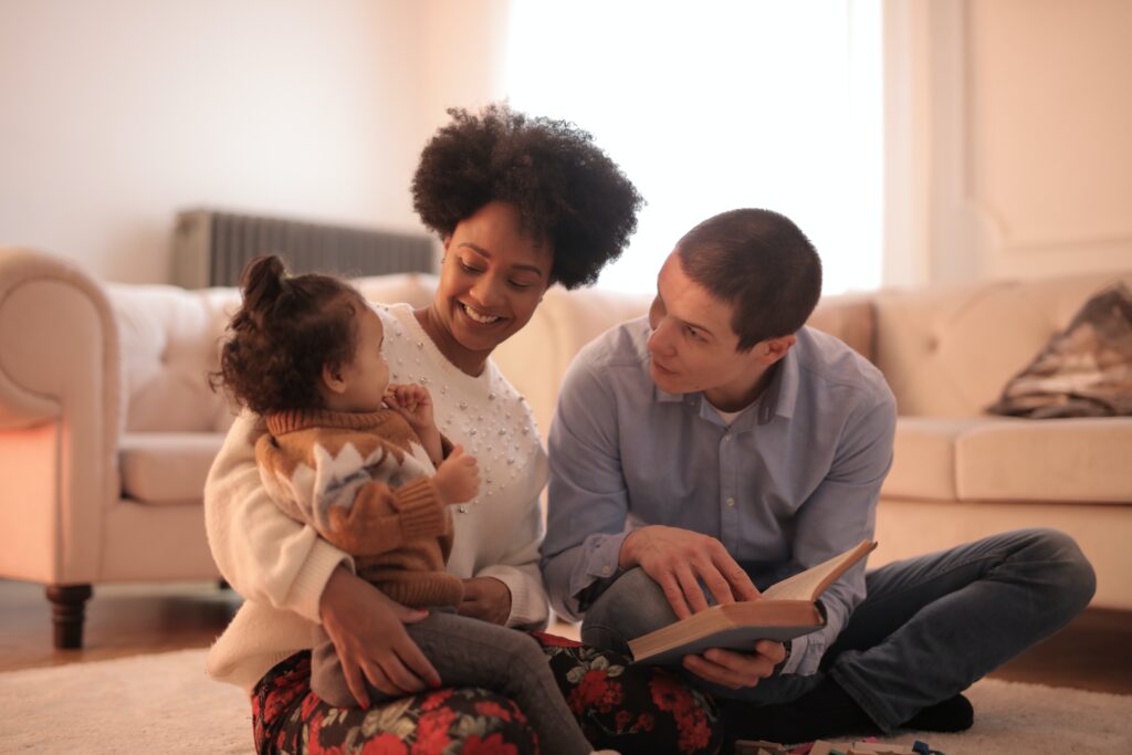 man reads to wife and child