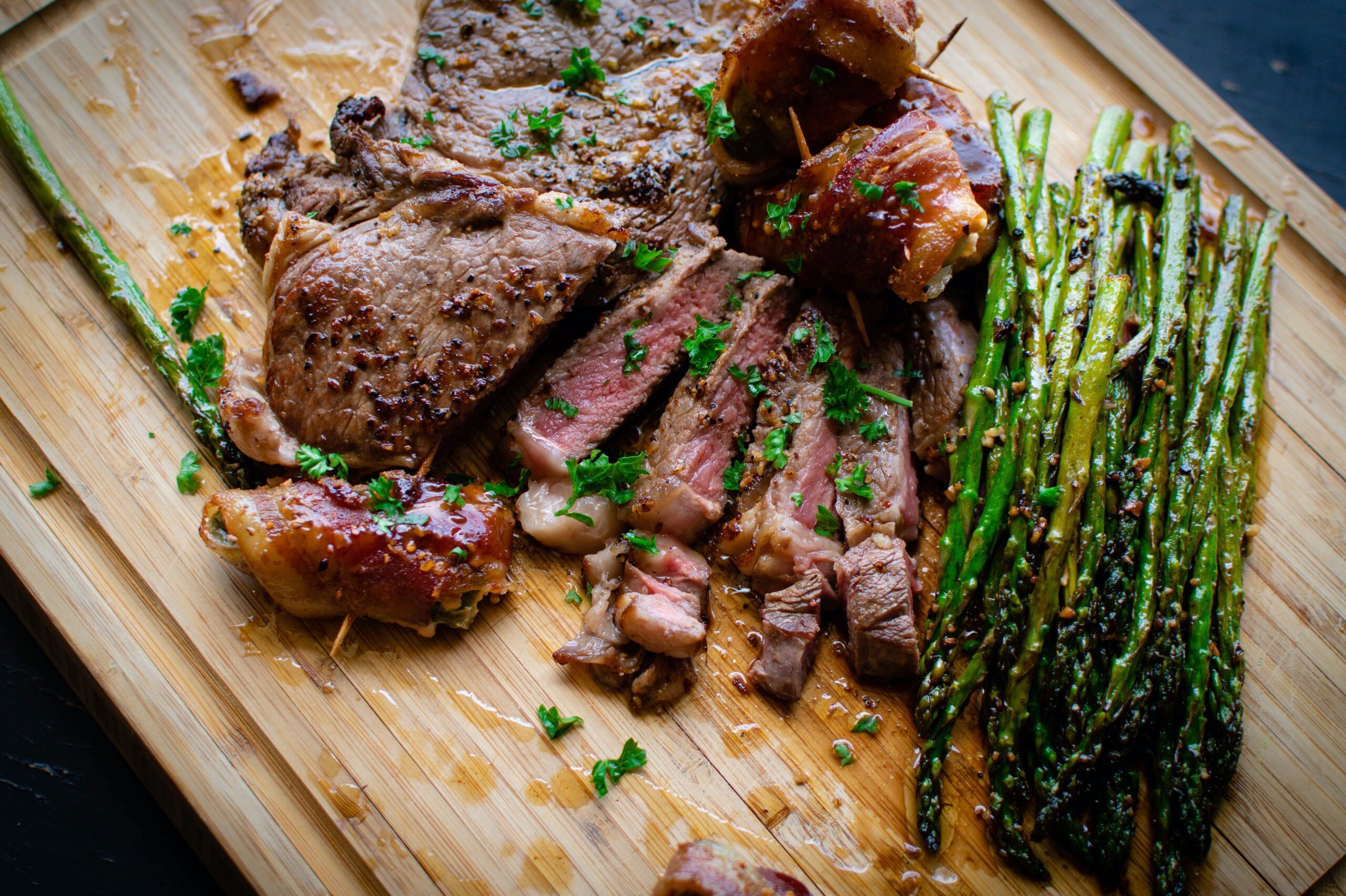 meat and asparagus on cutting board